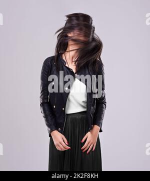 Rende la moda attraente. Scatto di una donna in studio vestito di abbigliamento alla moda. Foto Stock