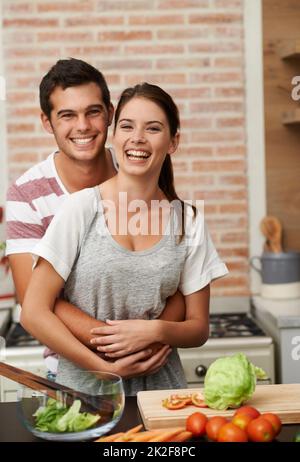 Il loro ingrediente segreto è l'amore. Ritratto di una coppia giovane attraente che si lega in cucina. Foto Stock