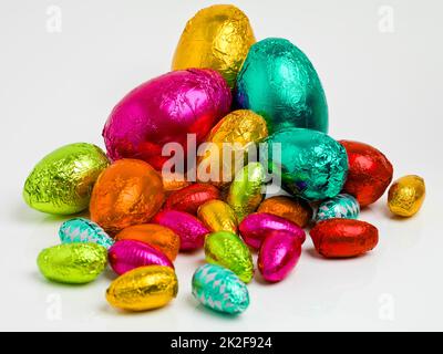 Edifici di Pasqua. Studio girato di una gamma abbagliante di uova di pasqua multicolore avvolto in foglio. Foto Stock