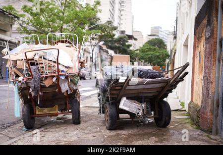 La povertà abbonda. Shot di carrelli pieni di immondizia nella strada di un quartiere povero. Foto Stock