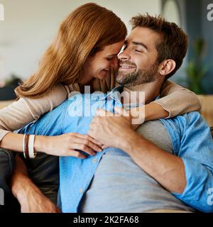 Theyre così nell'amore. Scatto corto di una giovane coppia affettuosa che si rilassa sul divano a casa. Foto Stock