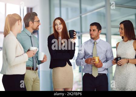 Il caffè facilita sempre le discussioni importanti. Shot di colleghi che hanno una discussione e bere caffè in un ufficio moderno. Foto Stock