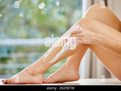 Preparare le gambe per l'estate. Scatto corto di una donna irriconoscibile che rasa le gambe in bagno. Foto Stock