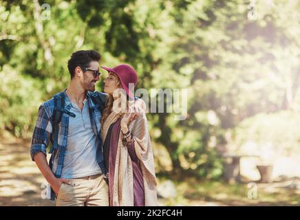 Passeggiate nei boschi. Scatto corto di una giovane coppia affettuosa durante un'escursione. Foto Stock