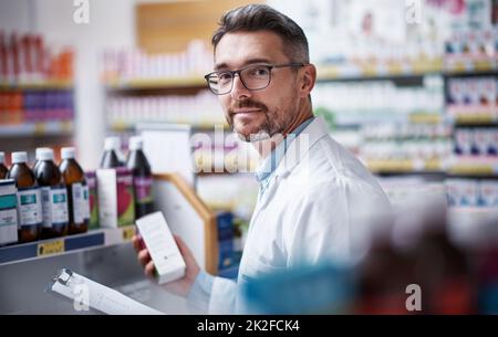 Se qualcosa vi aiuterà a sentirsi meglio, questo sarà. Ritratto di un farmacista maturo che fa inventario in una farmacia. Foto Stock