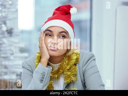 Non vedo l'ora di uscire qui. Scatto di una donna triste giovane perso nel pensiero alla sua scrivania in ufficio. Foto Stock