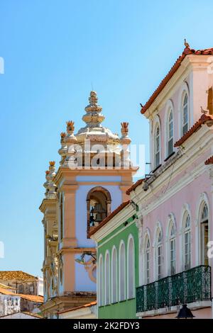 Case colorate facciate con balcone e torri storiche della chiesa Foto Stock