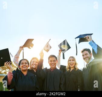 E 'sorprendente per finalmente laurearsi. Ritratto di un gruppo di studenti che festeggia il giorno della laurea. Foto Stock