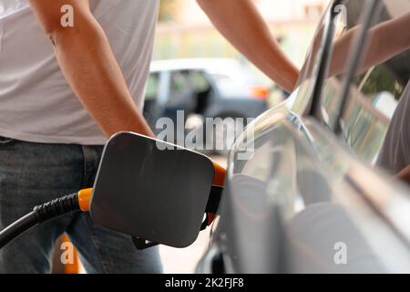 Manuale uomo rifornimento e rifornimento di combustibile di benzina di petrolio alla stazione. Riempire la macchina con combustibile. Foto Stock