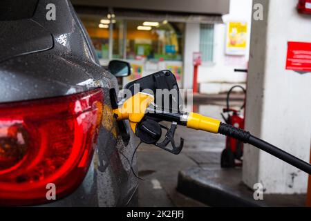 Pompare benzina combustibile in automobile a stazione di benzina. Rifornimento dell'automobile con benzina o diesel con un distributore di carburante. Foto Stock
