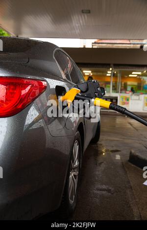 Pompare benzina combustibile in automobile a stazione di benzina. Rifornimento di carburante per auto presso la stazione di servizio. Il servizio di assistenza prevede il rifornimento di gas o biodiesel nel serbatoio. Foto Stock