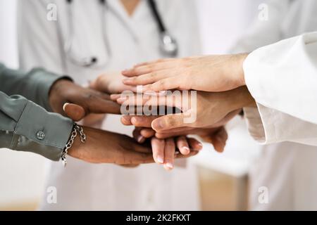 Team medico che si accatastano le mani Foto Stock