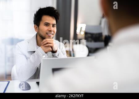 Manager femminile intervistando Un giovane maschio Foto Stock