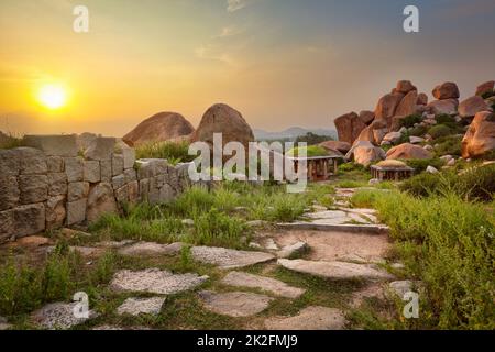 Fra le antiche rovine di Hampi sul tramonto. India Foto Stock