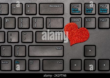 Tema del giorno di San Valentino, cuore rosso sulla tastiera del computer portatile Foto Stock