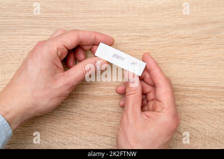 Mano che mostra il test dell'antigene rapido Covid-19 negativo Foto Stock