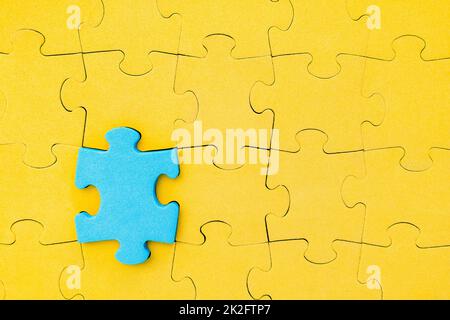 Il puzzle blu spicca dalla folla Foto Stock