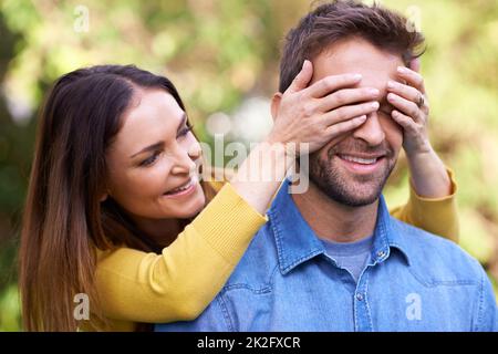 Le gioie delle sorprese. Scatto di una giovane coppia felice che è giocoso fuori. Foto Stock