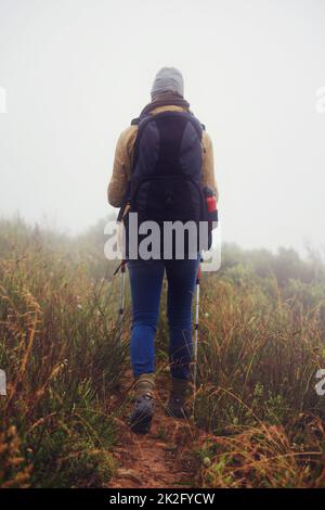 Si sente a casa nel deserto. Vista posteriore di una giovane donna che si fa un'escursione lungo un sentiero in una giornata colma. Foto Stock