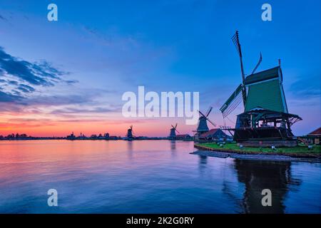 Mulini a vento nel famoso sito turistico Zaanse Schans in Olanda con cielo drammatico. Zaandam, Paesi Bassi Foto Stock