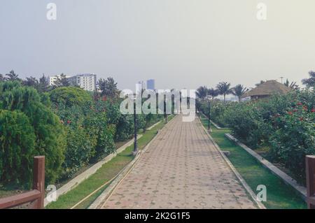 Sentiero in mattoni lungo il giardino alberi su un parco pubblico - sfondo naturale paesaggio nel tramonto estate. Eco Tourism Park Kolkata India Asia meridionale Foto Stock