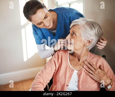Non c'è mai da chiedersi dove sono. Shot di una donna anziana in sedia a rotelle che viene curata per un'infermiera. Foto Stock