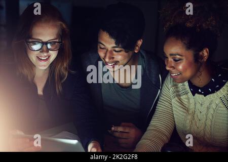 Mettendo in quell'ora supplementare come squadra. Scatto ritagliato di un gruppo di giovani che lavorano tardi in ufficio. Foto Stock