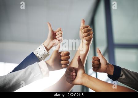 Youre che fa un lavoro grande sul fare successo accadere. Scatto ritagliato di un gruppo di uomini d'affari irriconoscibili che mostrano i pollici in su. Foto Stock