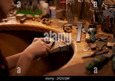 Le abilità che mio padre mi ha insegnato. Una persona che utilizza un attrezzo per lavorare su un pezzo di legno. Foto Stock