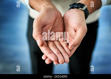 Mi trovo davanti a te con le mani aperte. Primo piano di una persona irriconoscibile che raggiunge con le mani aperte su uno sfondo blu. Foto Stock