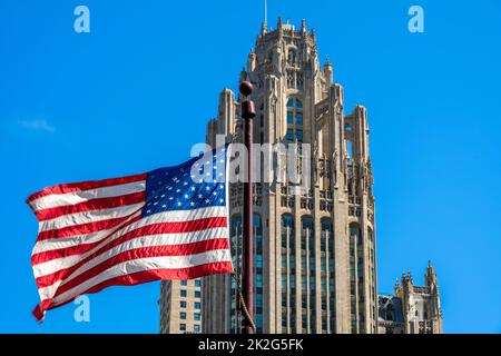 Sventolando la bandiera degli Stati Uniti con Tribune Tower dietro, Chicago, Illinois, USA Foto Stock