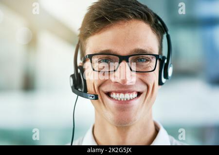 Chiamaci oggi stesso per ricevere un servizio eccellente. Ritratto di un giovane agente del call center che lavora in ufficio. Foto Stock