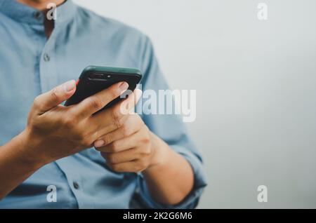 Primo piano di un uomo che utilizza lo smartphone mobile cercando in Internet, inviando sms, utilizzando SMS o online banking.spazio copia. Foto Stock