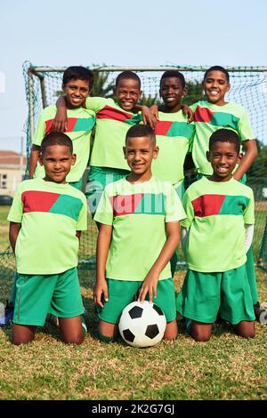 Posa orgogliosa per la foto della squadra. Ritratto di una squadra di calcio ragazzi su un campo sportivo. Foto Stock