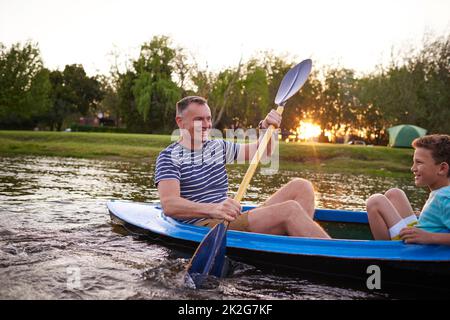 Questa è la vita, non è figlio. Sparato di un padre e di un figlio che remano una barca insieme su un lago. Foto Stock