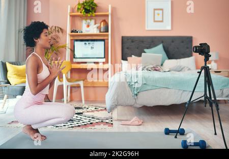 Ora il suo tempo per alcuni esercizi di respirazione. Scatto di una giovane donna che si registra mentre si esercita a casa. Foto Stock