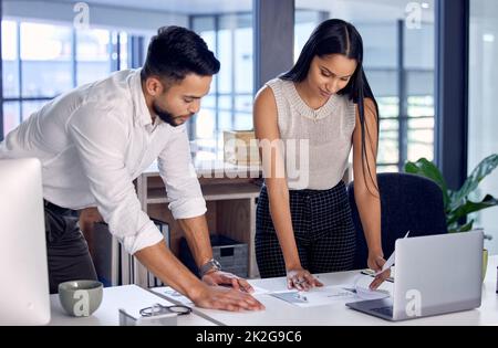 Approverà questi documenti per favore. Immagine di due colleghi di lavoro che leggono insieme alcuni documenti. Foto Stock