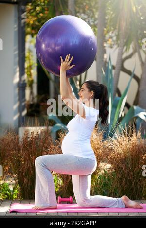 Stare in forma durante tutta la gravidanza. Shot di una giovane donna incinta che si esercita all'esterno. Foto Stock