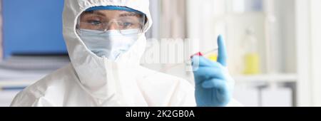 Scienziato in tuta protettiva e occhiali di protezione conduce la ricerca in laboratorio Foto Stock