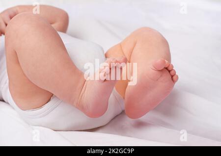 Le sue orme avranno bisogno di una guida, le gambe e i piedi di un bambino in uno studio. Foto Stock