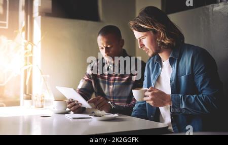 Che non sembra buono. Scatto di due amici con un tablet mentre si caffè in un bar. Foto Stock