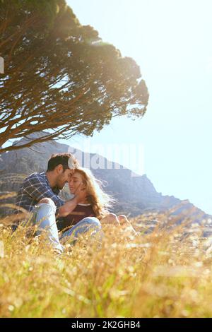 Potete sentire il calore del loro amore. Shot di una giovane coppia affettuosa che si gode una giornata all'aperto. Foto Stock