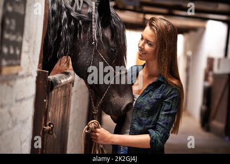 Ehi ragazza, perché. Una giovane donna in una stalla con il suo cavallo. Foto Stock