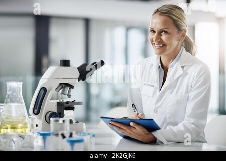 Ive ha qualcosa. Ritratto corto di una scienziata matura attraente femmina che prende appunti mentre fa la ricerca nel suo laboratorio. Foto Stock