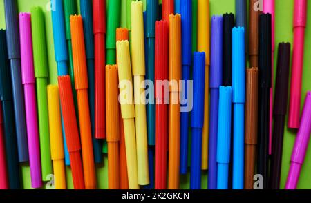 Il colore parla più forte delle parole. Studio di diverse penne in feltro colorato su sfondo verde. Foto Stock