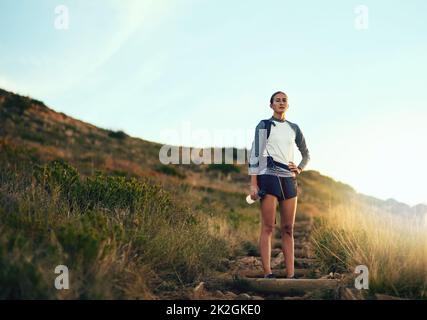 Im qui per conquistare i grandi spazi aperti. Ritratto di una giovane donna in un'escursione attraverso le montagne. Foto Stock