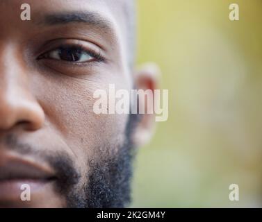 Gli occhi raccontano una storia diversa. Primo piano di un lato di un giovane uomo volto. Foto Stock