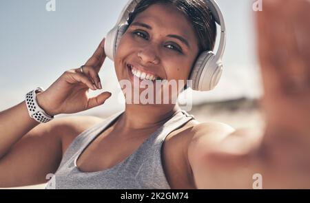 L'esercitazione li fa ritenere buoni, i benefici sono evidenti. Scatto di una giovane donna che indossa le cuffie mentre sei fuori per un allenamento. Foto Stock