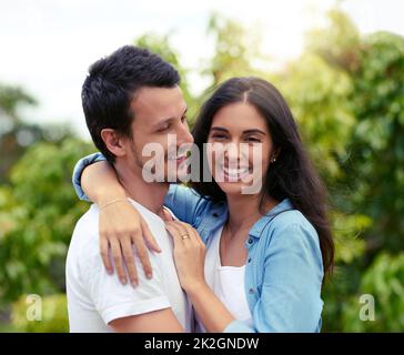 Un abbinamento perfetto. Scatto corto di una giovane coppia affettuosa che si abbraccia mentre si alza all'aperto. Foto Stock