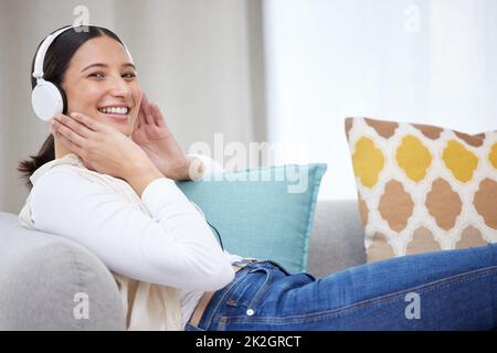 Concediti qualcosa di divertente da fare. Scatto di una giovane donna che ascolta musica a casa. Foto Stock